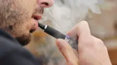 Un hombre fumando un cigarrillo electrónico