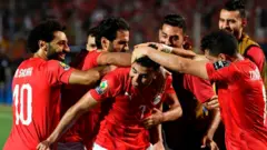 Le milieu de terrain égyptien Mahmoud Hassan dit ''Trezeguet'' (au centre) célèbre son but avec ses coéquipiers.
