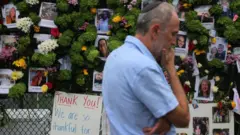 Un hombre con kipá contempla uno de los memoriales a las víctimas de las Torres Champlain Sur.