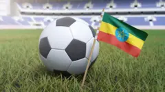 ኣብ ሜዳ ዘላ ኩዕሶ እግሪ ምስ ባንዴራ ኢትዮጵያ