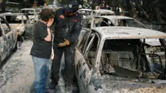 A woman reacts as she tries to find her dog, following a wildfire at the village of Mati, near Athens, Greece July 24, 2018