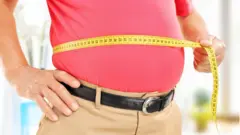 Homem de idade mede sua barriga