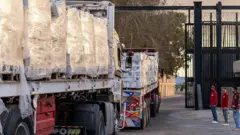 Caminhões carregados com ajuda humanitária entrando em Gaza pela passagem de Rafah