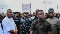 Aworan yii ṣafihan awọn ọkunrin to leju koko nibi iwọde Isanlu Isin, ipinlẹ Kwara. Awọn ọlọpaa ati awọn araalu