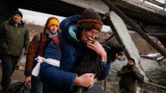 A man holds his dog as he walks below a destroyed bridge as Russia"s attack on Ukraine continues in Irpin outside Kyiv, 9 Ukraine 9 March