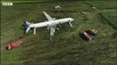 Equipes de resgate ao redor de avião que pousou em milharal