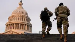 National Guard members walk at the Capitol in Washington on January 15, 2021