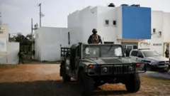 Troops stand guard at the morgue where the Americans' bodies were taken
