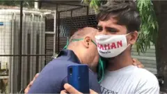 முதியவரை ஆறுதல் படுத்தும் இளைஞர்