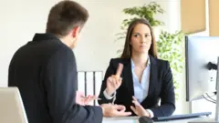 Une femme bouge son doigt négativement