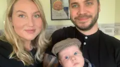 Megan Willis y John Hall, junto a su bebé Edward.
