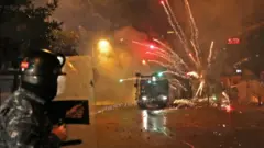 Young Shia men throw fireworks at security forces in Beirut, Lebanon (17 December 2019)