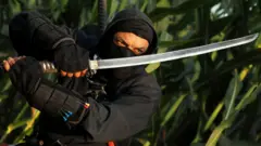 Abdel Qader Ahmed, a self-taught ninja enthusiast known as Abouda Ninja, holds a sword he made himself, at a field in the Sharqia Governorate, north of Cairo, Egypt August 13, 2021.