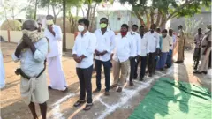 క్యూలో నిలుచున్న వైసీపీ అభ్యర్తి గురుమూర్తి