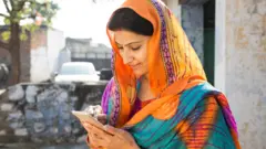 ਸਿਰ 'ਤੇ ਦੁਪੱਟਾ ਲਈ ਮੋਬਾਈਲ ਫੋਨ ਦੇਖ ਰਹੀ ਮਹਿਲਾ 