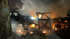 Burning cars on a street in west Belfast