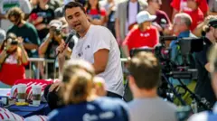 Charlie Kirk, vestido con una camiseta blanca, hablando a las cámaras en el evento donde le dispararon.