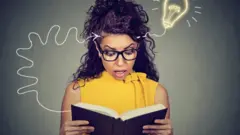 Кыз китеп окуп жатат