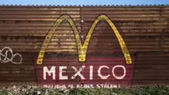 Un pedazo del muro que separa a México del suroeste de EE.UU. con un grafiti del logo de McDonald's y la palabra "México".