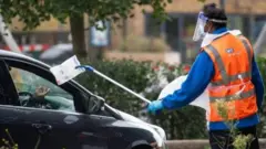 የፊት ጭምብል ያደረገ የፓርኪንግ ሰራተኛ