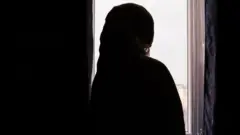 امرأة تنظر من إحدى النوافذ