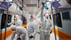 Employees of the Istanbul Municipality wearing protective gear disinfects a subway carriage 12 March 2020