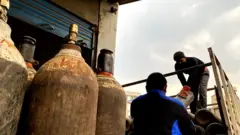 अक्सिजन सिलिन्डर झार्दै मजदूर।