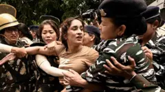Security personnel detain wrestler Vinesh Phogat during wrestlers' protest march towards new Parliament building, on May 28