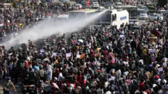 Police fire a water cannon at protesters demonstrating against the coup and to demand the release of elected leader Aung San Suu Kyi, in Naypyitaw, Myanmar, February 8, 2021.