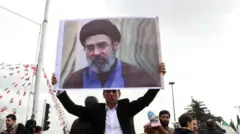 Man hold foto of Mojtaba Khamenei
