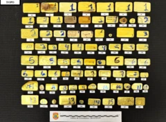 Barras de ouro apreendidas pela Polícia Rodoviária Federal (PRF) em uma rodovia que liga o Brasil à Guiana enfileiradas sobre um fundo preto