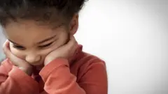 Girl, distracted, touching her face