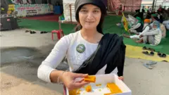 మిఠాయిలు పంచుతున్న యువతి