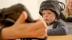 মস্তিষ্কের কার্যকলাপ স্ক্যান করার জন্য শিশুদের জন্য সেন্সর বোঝাই বিশেষ টুপি রয়েছে।