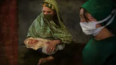 மருத்துவருடன் ஆப்கன் பெண் மற்றும் அவர் குழந்தை