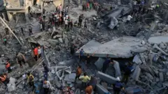 パレスチナ自治区ガザ地区中部のマガジ難民キャンプで、爆発後のがれきの中で救助作業などに当たる人たち