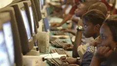 Des enfants apprennent a se servir d'un ordinateur
