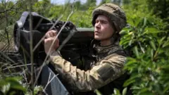 A Ukrainian soldier holds an anti-tank weapon တင့်ဖျက်