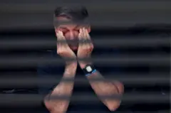 O ex-presidente brasileiro Jair Bolsonaro cobre os olhos em sua casa enquanto cumpre prisão domiciliar