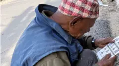 काठमाण्डूको हाँडीगाउँमा उम्मेदवारको सूची हेर्दै एकजना वृद्ध