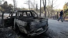 Atina'nın kuzeyindeki yangınlarda yanan bir araç