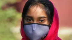 మాస్కు ధరించిన బాలిక