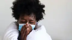 Woman with mask on sneezes