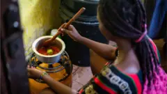 Umugore ariko aratekesha gas (isanamu yo mu bubiko/archive)