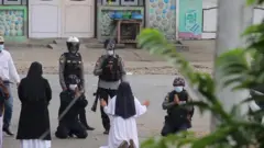 सन् २०२१ मा विश्वभर चर्चित भएको तस्बिरमा सिस्टर एन रोज नु टङले प्रदर्शनकारीलाई बचाउन प्रहरीसामु घुँडा टेकेको देखिन्छ।