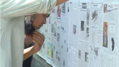 দেয়ালে সাঁটা দৈনিক পত্রিকা পড়ছেন একজন পথচারী।