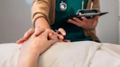 Una médico con un paciente terminal.