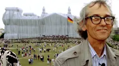Conceptual artist Christo poses for photographers in front of the wrapped Reichstag, 26 June 1995