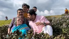 87 வயது தாயை நீலக்குறிஞ்சி பூக்களைப் பார்க்க சுமந்து சென்ற மகன்கள்