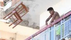 Aşağı sandalye atan bir apartman sakini